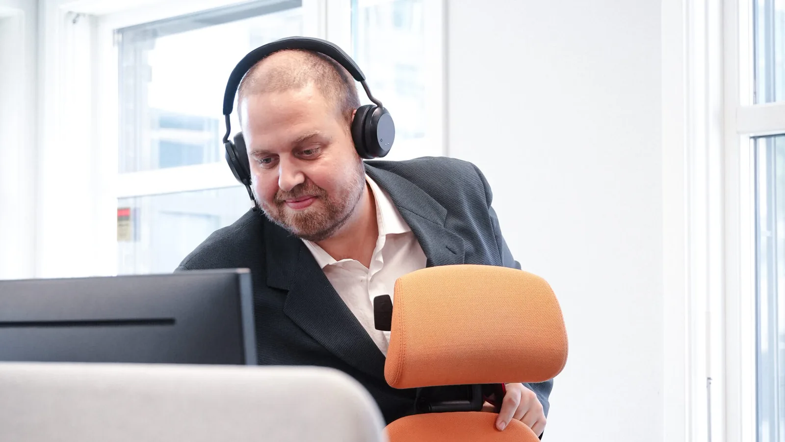 Salgsrådgiver hos Salgskompetanse i arbeid med headset ved kontorplassen