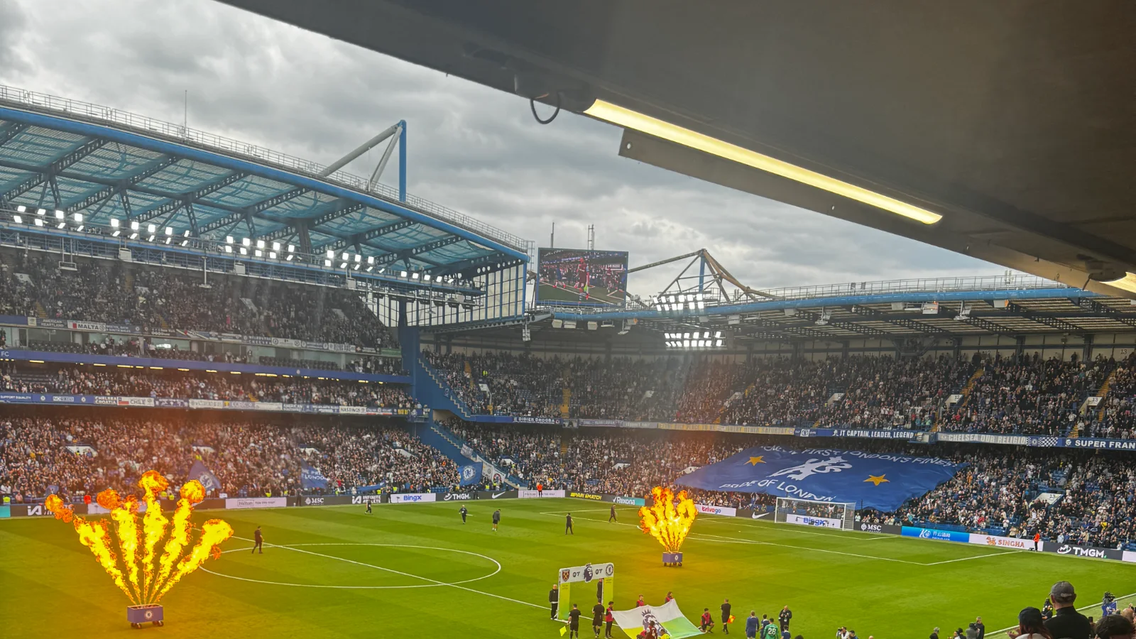 Stamford Bridge før avspark, med flammer på banen og fullsatte tribuner